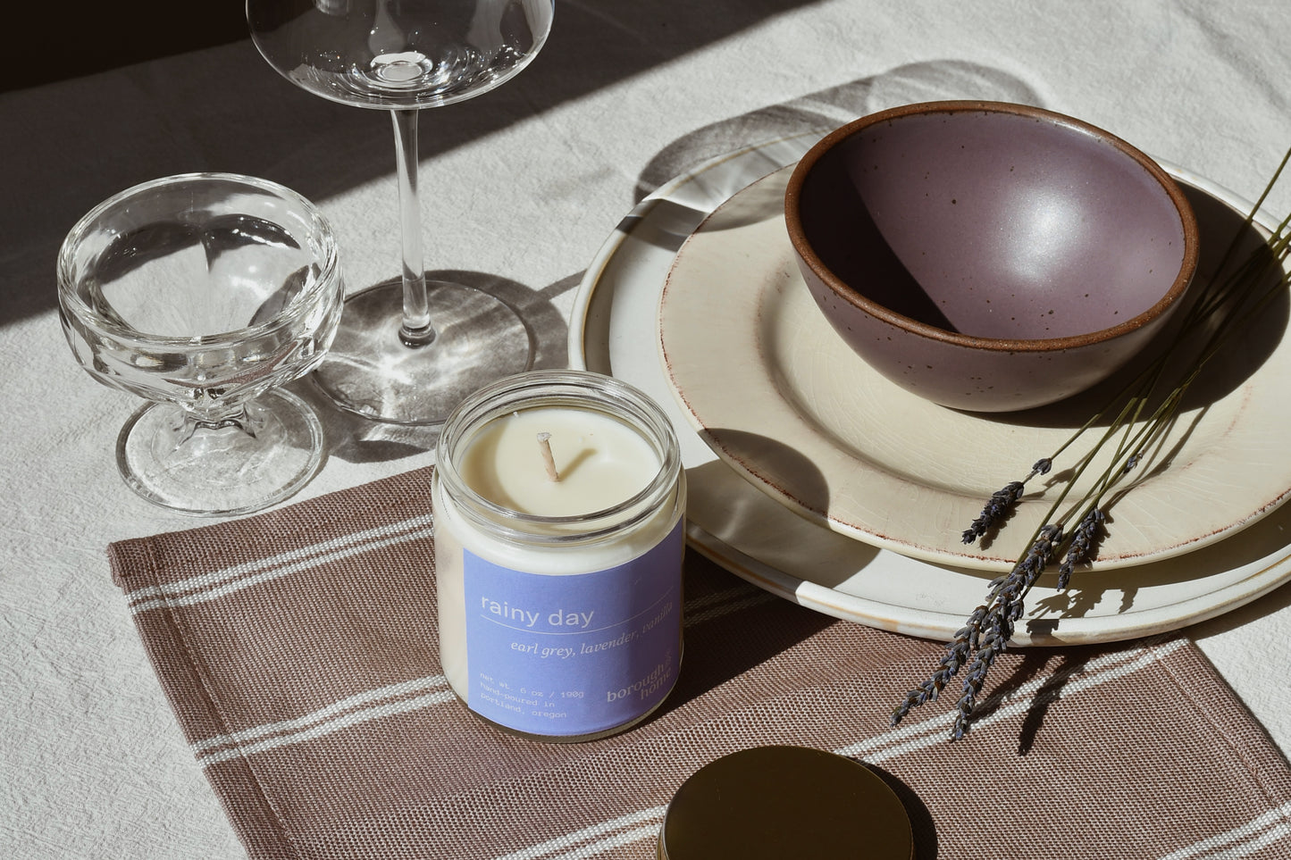 Horizontal tablescape with Rainy Day candle, top down view.